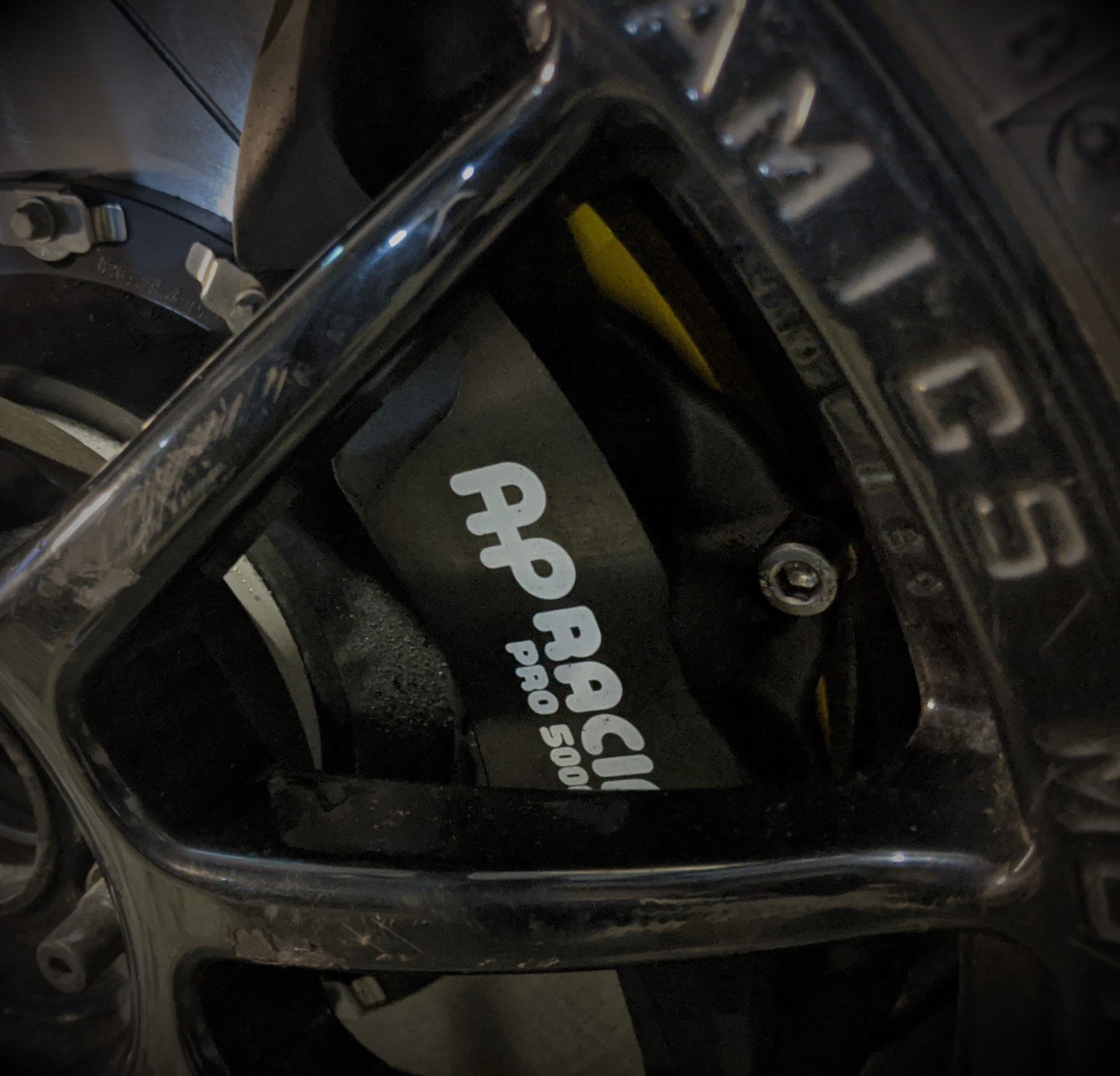 An AP Racing brake caliper behind a wheel