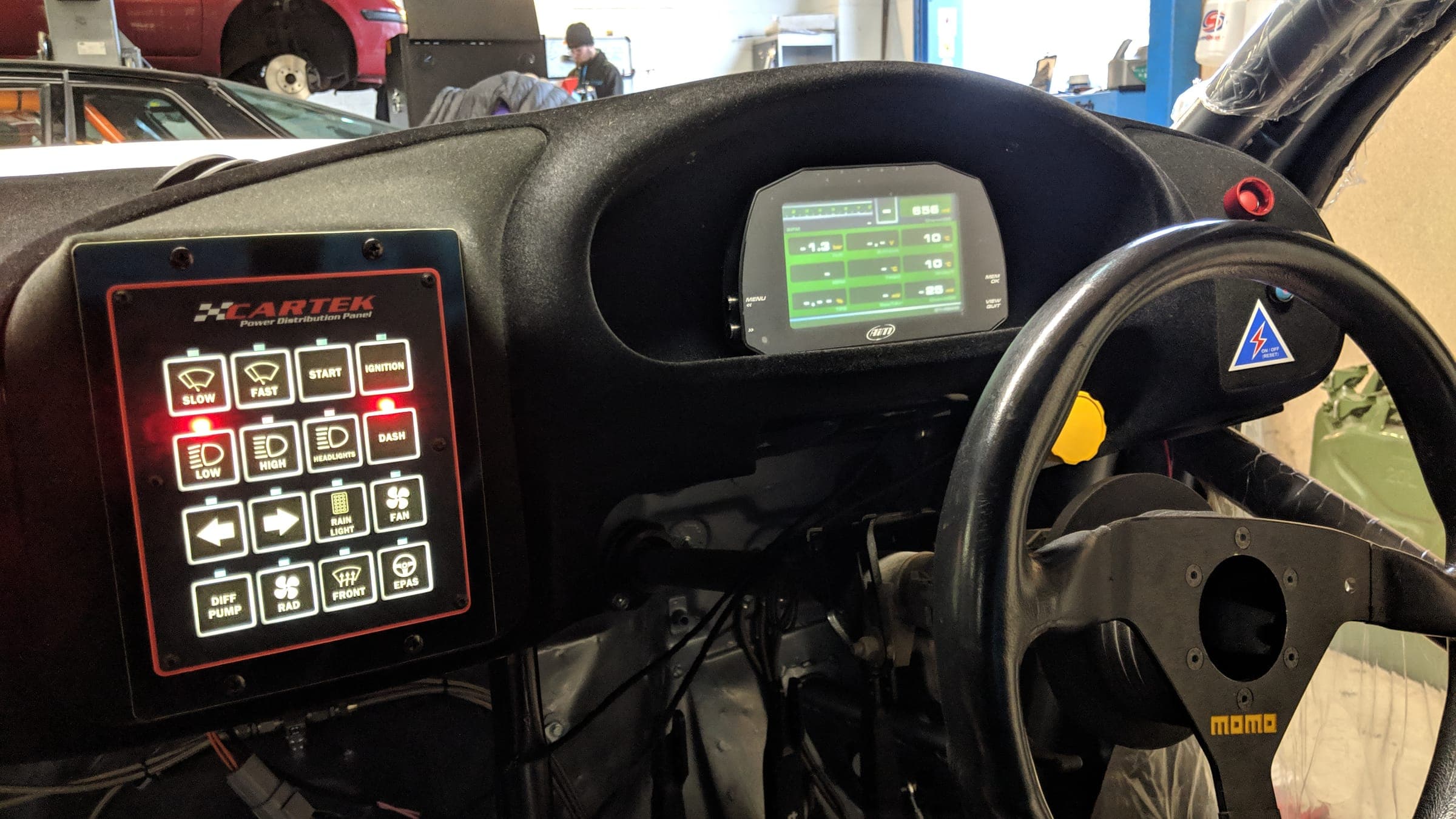 The dash, switch panel and wheel of a race car